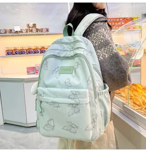 Foto de estilo de vida de la mochila estampada verde menta con colgante de peluche