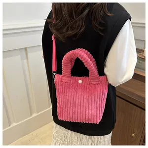 Detailed texture of rose pink corduroy tote bag featuring thick handles and strap