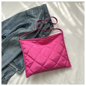 Close-up of bright magenta quilted nylon hobo bag with diamond stitching pattern