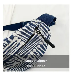 Detail of smooth metal zipper and blue striped woven fabric on casual chest bag