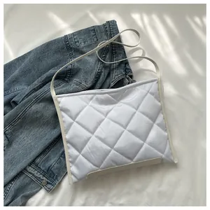 Detail of white quilted rhombus shoulder bag on a casual blue denim jacket