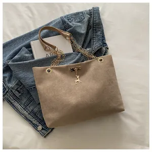 Détail du sac cabas en daim kaki avec pendentif cerf doré et bandoulière en chaîne