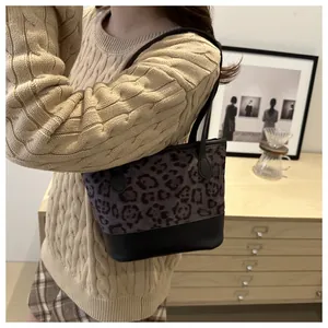 Detail of leopard print stitching shoulder bag with black leather strap on a model
