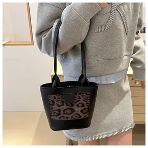 Detail of a chic black bucket tote with leopard print panel and long top handles