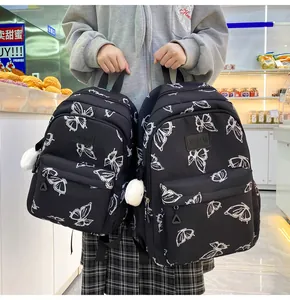 Detalle de mochila de nailon negra de estilo coreano con estampado de mariposas y felpa