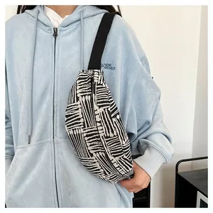 Detail of canvas chest bag with black and white geometric stripes on a casual model