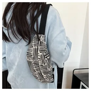 Detail of canvas chest bag featuring black and white geometric stripes and wide strap