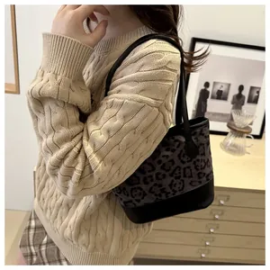 Close-up of leopard print mini tote bag styled with a cream knit sweater for winter
