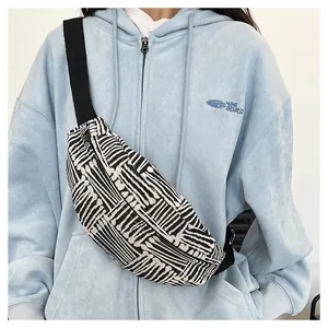 Close-up of black and white geometric canvas chest bag with durable woven strap