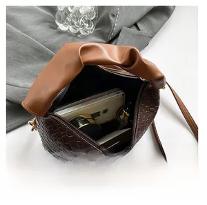 Internal view of brown crocodile texture handbag showing large storage capacity and gold zipper