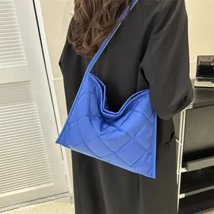 Navy blue quilted hobo bag with large capacity displayed on a shoulder for casual wear