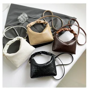 Detailed overhead view of woven leather shoulder bags in white, beige, brown, and black