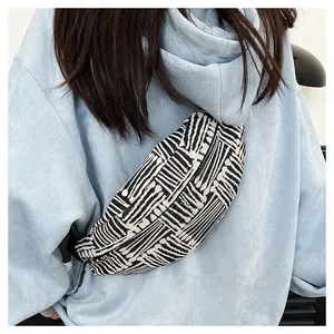 Detail of canvas chest bag featuring black and white geometric stripes and smooth zipper