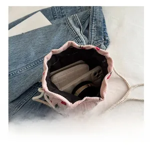 Top view of pink corduroy strawberry bucket bag showing internal capacity and daily items