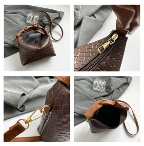 Detail of dark brown woven shoulder bag with gold zipper and stylish pleated handle