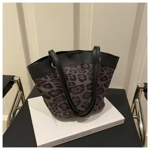 Detail of leopard print tote bag with black faux leather handles and silver metal rings