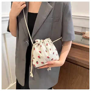 Close-up of cute strawberry print corduroy drawstring bucket bag with cotton strap