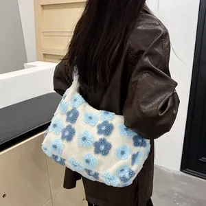 Plush floral tote bag in white with blue flowers shown in a casual over-the-shoulder view