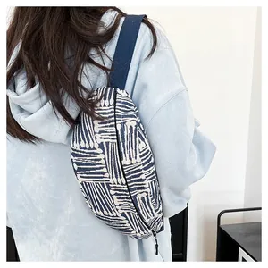 Detailed back view of a canvas crossbody bag with navy geometric patterns on female model
