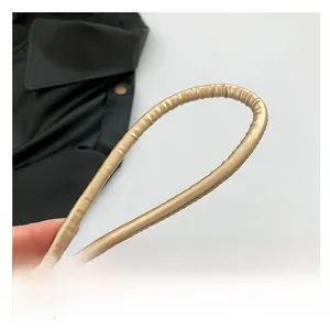 Detail of a padded golden PU leather shoulder strap showing metallic texture and flexibility