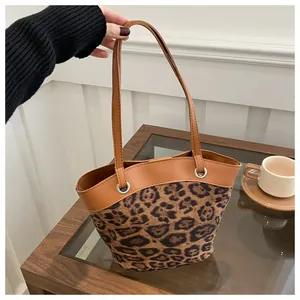 Detail view of leopard print tote bag with brown PU straps and metal ring accents
