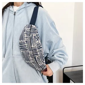 Detail of canvas belt bag with blue geometric patterns and adjustable nylon shoulder strap