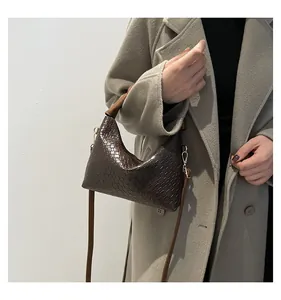 Detailed view of dark coffee woven hobo bag on model wearing a light grey wool coat