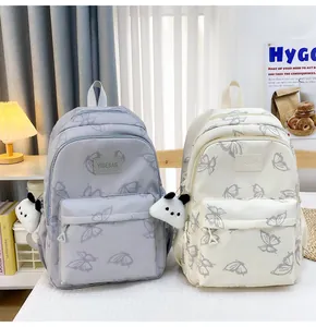 Detalle de mochilas escolares impermeables con estampados de mariposas y dijes de panda