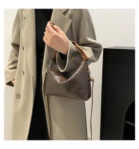 Detail of dark brown woven texture shoulder bag with light brown ruched top handle