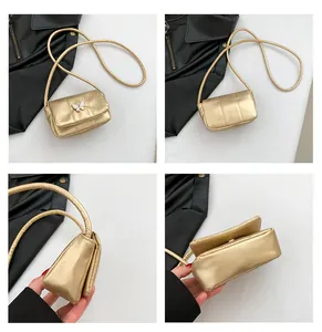 Detail view of a metallic gold mini square crossbody bag with white butterfly ornament