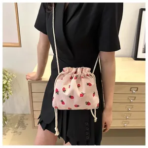 Detail of pink strawberry corduroy bucket bag with white drawstring closure