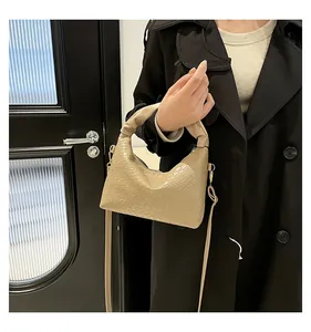 Close-up of beige hobo bag with crocodile texture and trendy ruched handle detail