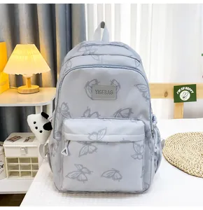 Detalle de la mochila azul claro con estampados de mariposas y un peluche de panda