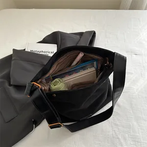 Minimalist black canvas tote bag with leather straps and large capacity for essentials