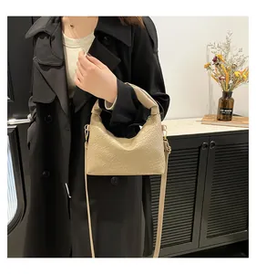 Detail of cream woven shoulder bag with checkered texture and detachable strap