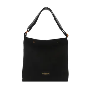 Minimalist black suede tote bag with bronze rings and adjustable wide shoulder strap