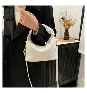 Close-up of white woven checkered texture and leather handle on stylish shoulder bag