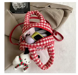 Détail montrant la capacité intérieure du sac à main en peluche à carreaux pour essentiels