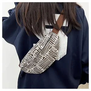 Close-up of geometric canvas chest bag with striped patterns and adjustable strap