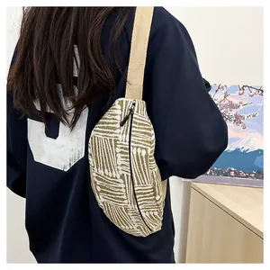 Detailed view of striped woven chest bag worn as a crossbody bag with wide strap