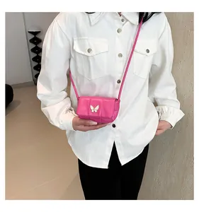 Detailed view of rose pink quilted mini crossbody bag with a white butterfly charm