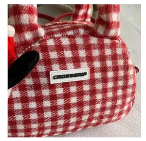 Détail du sac à main peluche à carreaux rouges et blancs avec le logo CROSSGRIP