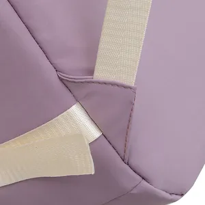 Detail showing the reinforced triangular stitching on purple fabric backpack strap