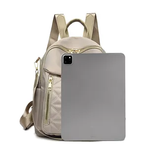 Dettaglio zaino in nylon champagne con confronto dimensioni iPad e trama trapuntata