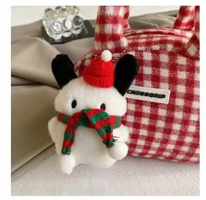 Détail d'un porte-clés peluche de Noël avec bonnet de Père Noël sur sac à carreaux