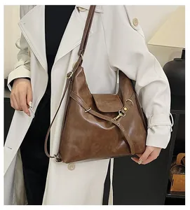 Detalle de bolso tote grande vintage marrón en piel sintética con solapa y hebilla metálica