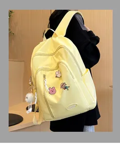 Détails du sac à dos en nylon jaune avec badges mignons et pompon en peluche