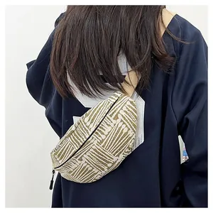 Close-up of geometric woven chest bag with beige and brown ethnic pattern and nylon strap