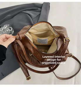 Primer plano de los compartimentos interiores organizados y el forro textil del bolso de cuero