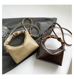 Detail of woven texture hobo bags in light and dark brown with gold metal accents